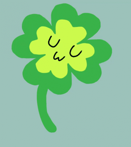 a green clover with black letters with eyes drawn on it