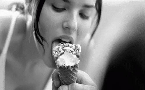 a young lady is eating ice cream with a scoop of it