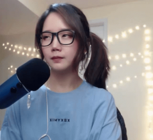 girl in glasses using a microphone while standing
