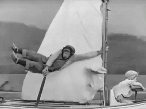 a man floating on top of a small sailboat