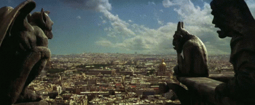 the view of paris from a window with a statue at the top