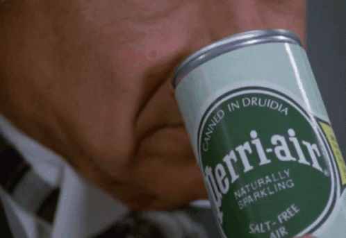 a green can of perrieral sitting on the lap of a person