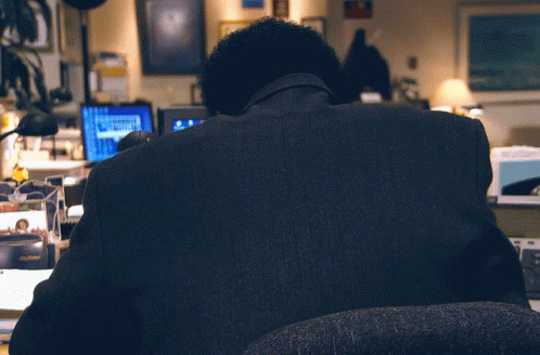 a man sitting in front of computer monitors