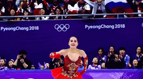 a woman wearing a blue dress is in the middle of the gymnastics floor
