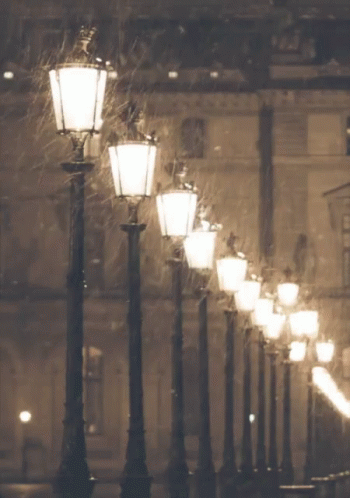 a dark night with street lamps and snow