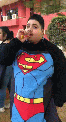 a person with a superman shirt on has soing in his mouth