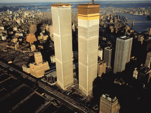 an aerial view of two tall skyscrs surrounded by a large city