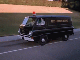 an old police van driving on a highway