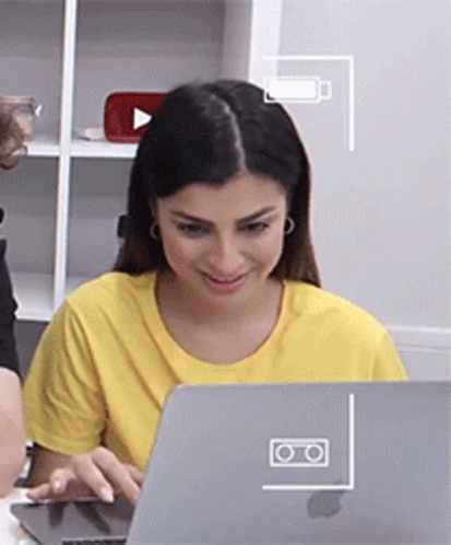 a woman smiling while looking at her laptop