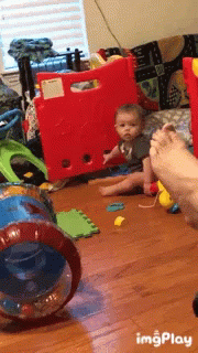 a little boy plays with his toys on the floor