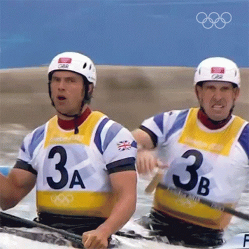 two men in colorful jerseys are paddling through the water