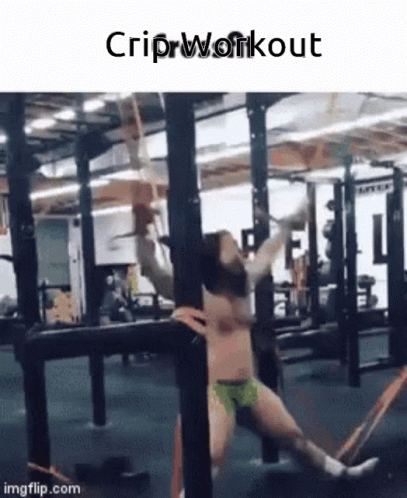a young man stretching in a gym with ropes