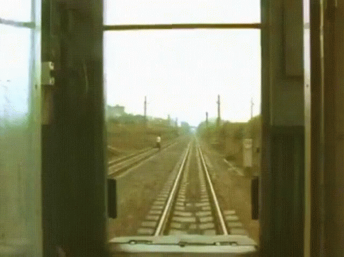 a man sitting at a train station looking out the window