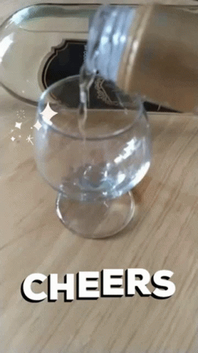 a person pouring soing into a glass on the floor