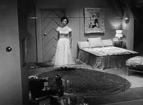 woman standing in an empty room near beds and lamps