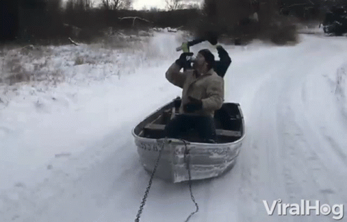 a man riding in a boat on snow covered ground