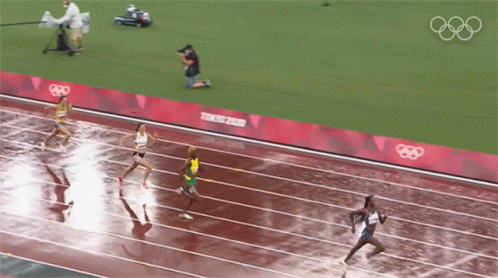 the olympic ceremony is underway as athletes run across a running track
