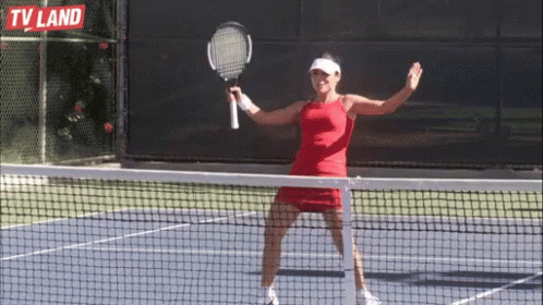 a woman in a purple shirt is playing tennis
