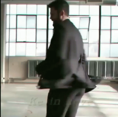 a blurry man in a suit walking inside