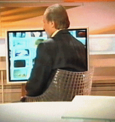 a man sitting in a chair watching television