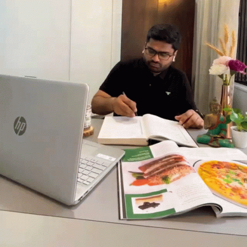 a man with glasses sitting at his laptop