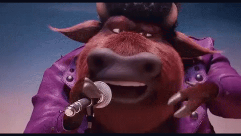 the blue and purple cow has a microphone in his mouth