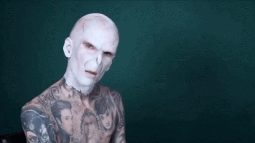 a man with white body paint and tattoos