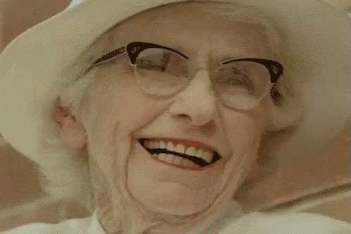 an old woman wearing a white hat and glasses