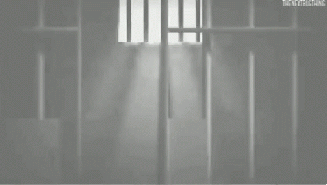 a person sitting on a bed in a  cell