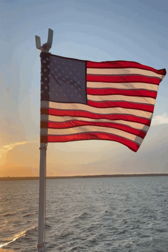a large flag flying over the ocean