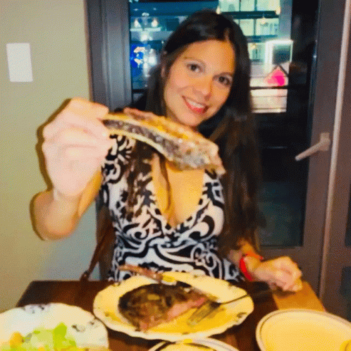 a woman is posing for a picture while eating dinner