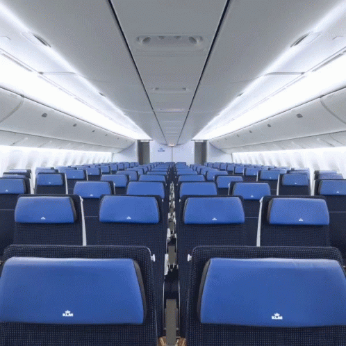 the interior of an airplane with orange seats and the windows