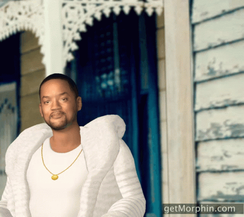 a man is dressed in white while posing outside a house