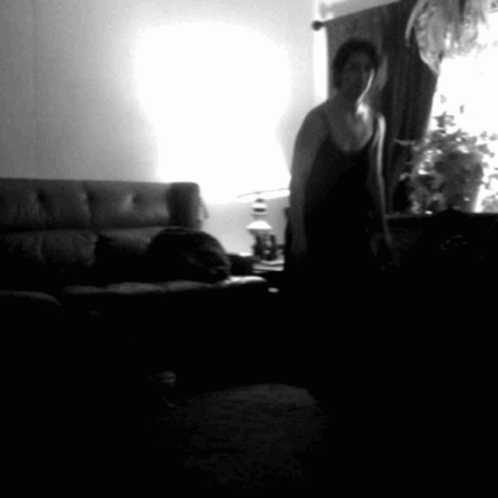 a man is in his living room standing near the sofa