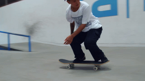 a person in a white shirt rides on a skateboard