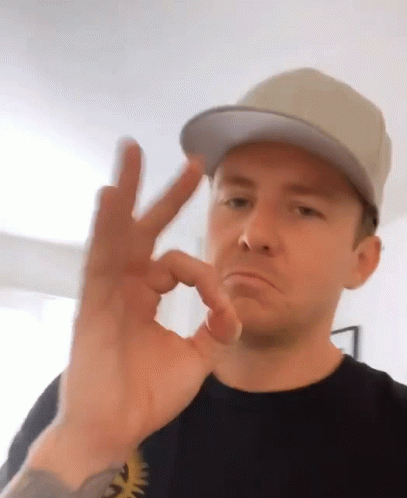 a man in a cap making the okay hand sign