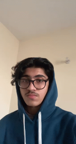 man wearing hoodie and glasses making silly face