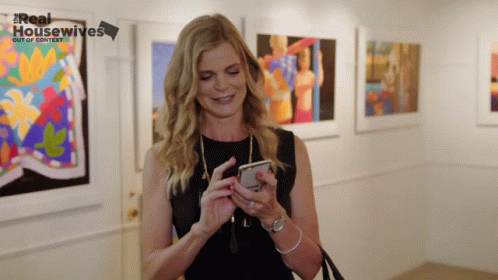 a woman looking at her phone and smiling