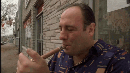 a man in a hawaiian shirt smoking on his cigar