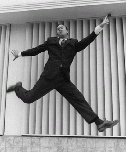 a man in a suit jumping to catch soing