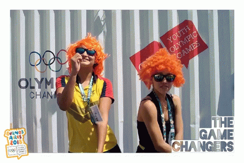 two blue women in wigs and shades are holding signs