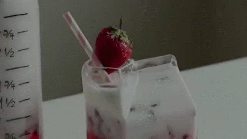 a frozen drink has been put in a glass with strawberries and ice