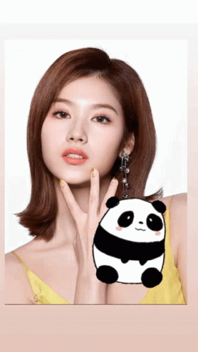 a woman with her hand on her face holding a panda keychain