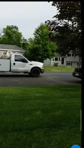 a truck parked on the side of the road in front of a house