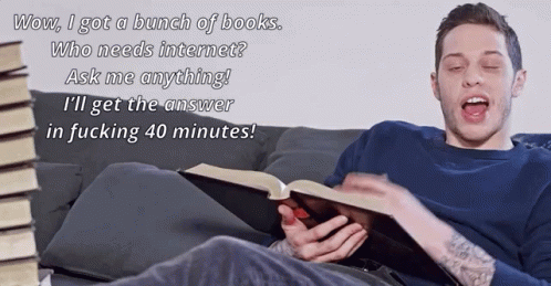 a young man is reading a book on a couch