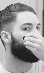 a man with a beard putting soing in his mouth