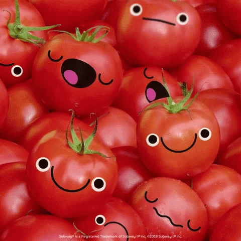 there are many tomatoes with faces drawn on them