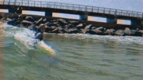 someone surfing in front of an ocean pier