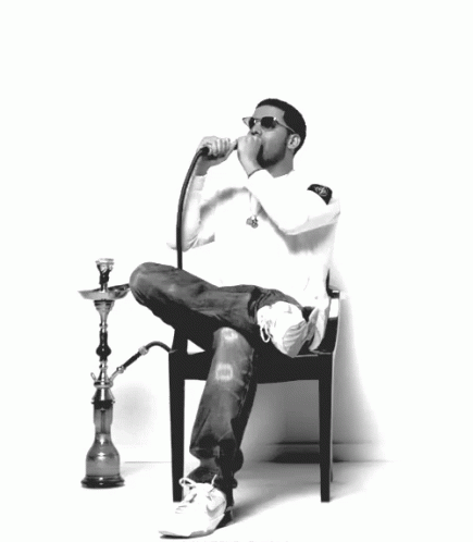 a black and white po of a man sitting on a chair with a hookah lamp