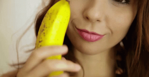 woman with pink lipstick and purple lip paints holding banana